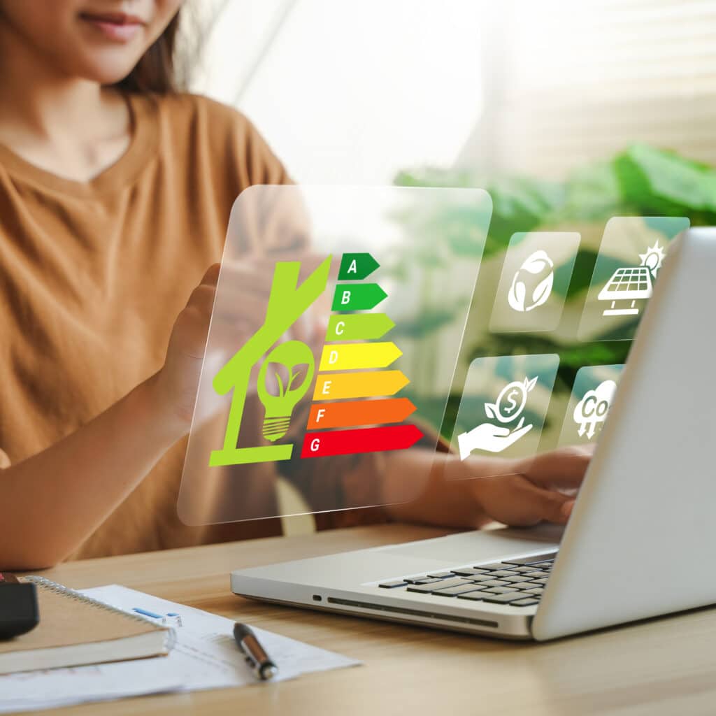 Efficacité énergétique : optimiser son habitat durable Femme analysant l'efficacité énergétique A-G d'une maison, icônes CO2 et économies sur un écran holographique.